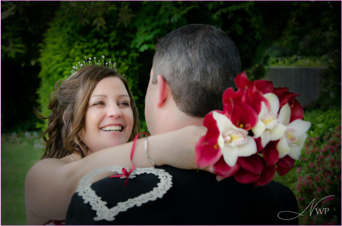 Bride hugs new husband in Berkshire hotel garden